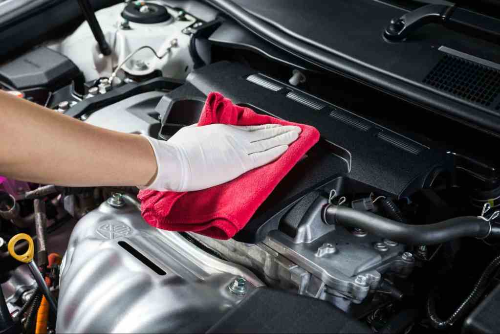 wiping down an engine bay with gloves and microfiber cloth