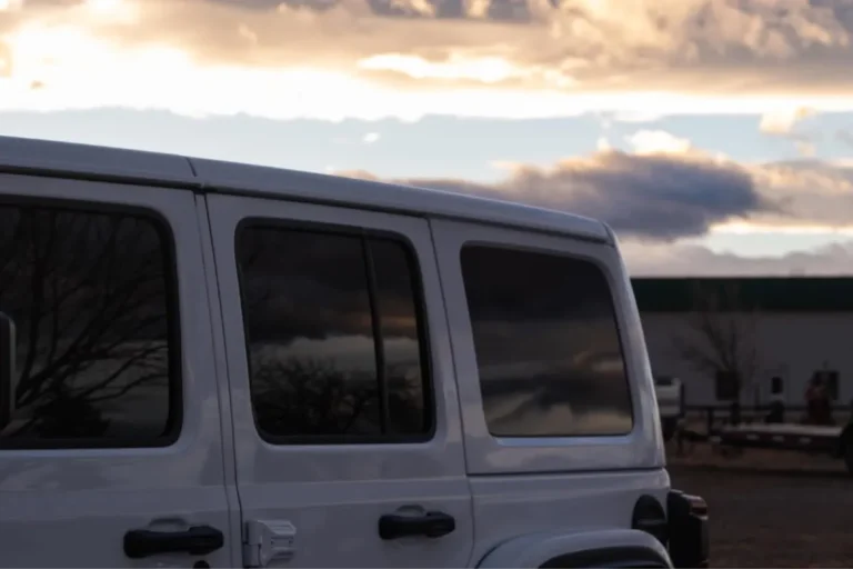 Clean, dark window tinting on a white SUV under a cloudy sunset sky